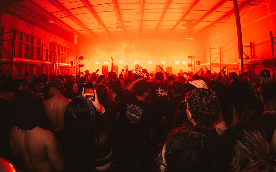 Packed warehouse crowd under red light